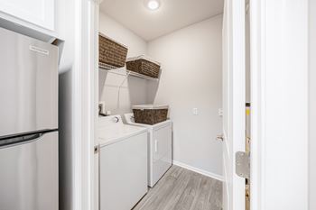 A white refrigerator is on the left of a small kitchen.